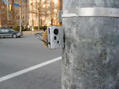 Figure 2: Top: A keychain camera is hacked via a microcontroller and outfitted with magnets for placement on a traffic pole near a bus stop. Bottom: Examples of time-lapse photographs retrieved from the keychain camera. Current camera resolution is 300 by 200 pixels from a $10 camera.