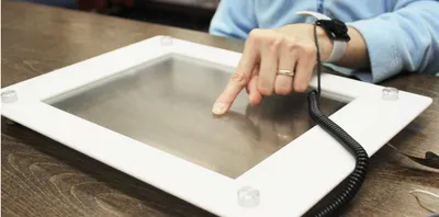 Figure 1. A blind user feels the TeslaTouch
