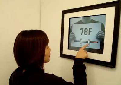 Figure 1. a) RayMatic is a playful interface to a home heating system. b) Adjusting the set-point on the RayMatic.